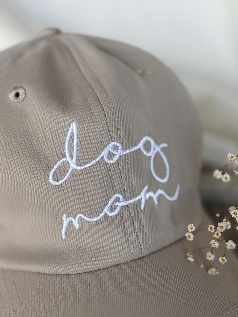 Peut inclure: Casquette de baseball beige avec l'inscription "dog mom" brod&eacute;e en blanc. La casquette a une visi&egrave;re incurv&eacute;e et un petit trou d'a&eacute;ration. Le design est simple et &eacute;l&eacute;gant, id&eacute;al pour un usage quotidien.