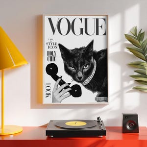 May include: A framed black and white Vogue magazine cover featuring a black cat wearing a jeweled collar and holding a vintage telephone receiver. The cover includes the Vogue logo and the words "I AM A STYLE ICON" and "HOLY CHIC".