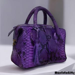 May include: A purple handbag with a snakeskin pattern. The bag has two handles, a zipper closure, and a decorative tassel. The bag is a deep shade of purple with darker accents.