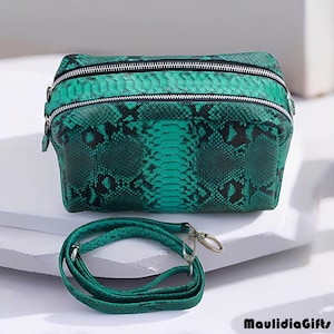 May include: A green snakeskin-patterned bag with two zippered compartments and a detachable shoulder strap. The bag is a vibrant shade of green with black accents, and the strap has silver-tone hardware.