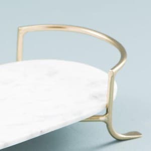 Elegant vanity tray with gold handles holding perfumes