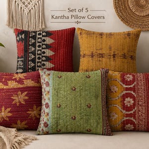 Könnte beinhalten: Ein Set aus 5 Kantha-Kissenbezügen mit verschiedenen quadratischen Kissen und aufwendigen Steppnähten. Die Designs umfassen rote, gelbe und grüne Muster mit floralen und geometrischen Motiven. Der Text Set of 5 Kantha Pillow Covers ist sichtbar.