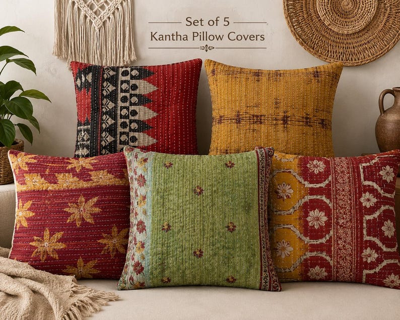 May include: A set of 5 Kantha pillow covers featuring various patterns and colors including red, yellow, and green. The square covers display intricate stitched details and diverse geometric and floral motifs, presented as a collection of decorative textiles.