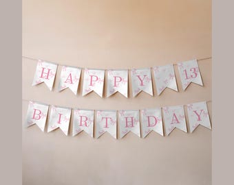 May include: A banner with white pennants, each adorned with pink bows and letters spelling "HAPPY BIRTHDAY 13". The banner is strung against a neutral background, suitable for a birthday celebration.