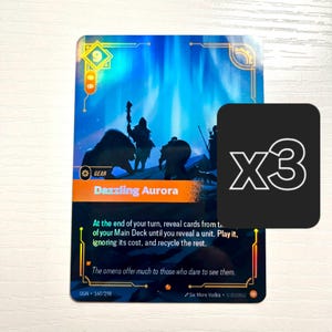 Puede incluir: Una carta coleccionable con un diseño azul y naranja, con el texto "Dazzling Aurora" y una silueta de figuras en un paisaje nevado. Un cuadrado negro con "X3" está en la esquina. La carta también tiene instrucciones del juego.