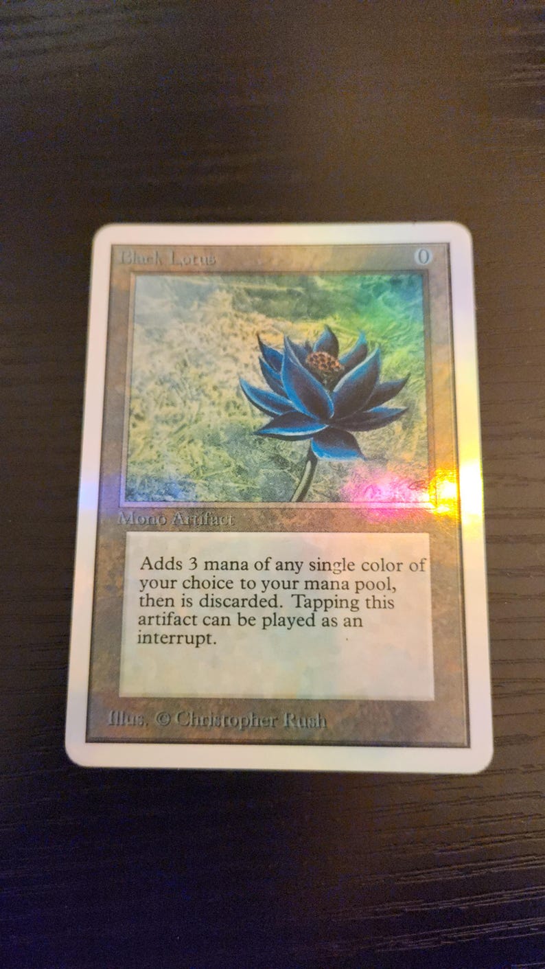 Pu&ograve; includere: Carta collezionabile con un fiore di loto blu. Intitolata "Black Lotus", include testo che descrive la sua funzione nel gioco. La carta ha una finitura olografica.