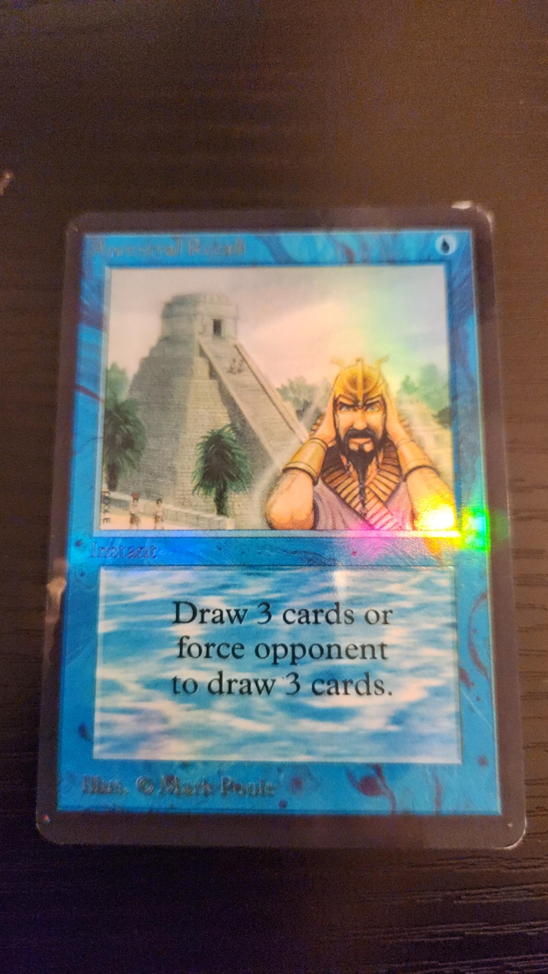 Pu&ograve; includere: Una carta blu di Magic: The Gathering con una scena di tempio e una figura con un elmo d'oro. Il testo della carta recita: "Pesca 3 carte o fai pescare 3 carte all'avversario."
