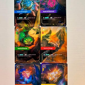 May include: Six trading cards featuring fantasy art and text. Each card has a unique design with titles like "Seal of Insight" and "Seal of Discord." The cards have a gold border and include the word "GEAR."