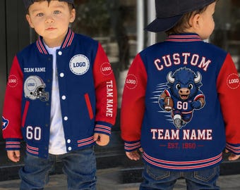 May include: A navy blue and red varsity jacket worn with a white t-shirt, blue jeans, and a dark blue baseball cap. The jacket features a football helmet graphic, the number 60, and a cartoon buffalo mascot with the text CUSTOM TEAM NAME EST. 1960.