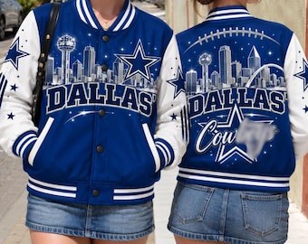 Puede incluir: Una chaqueta universitaria azul y blanca con un gráfico del horizonte de Dallas, un emblema de estrella grande y el texto DALLAS. La parte posterior muestra un gráfico de fútbol americano, el horizonte de Dallas y el texto DALLAS COWBOYS.