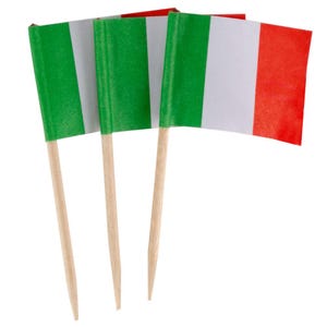 May include: Three small Italian flags on wooden toothpicks. Each flag features vertical stripes of green, white, and red. The flags are made of paper and are ideal for decorating food or use at a party.