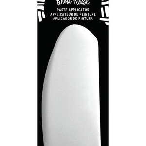 May include: A white paste applicator with a rounded top and a black background. The text "Brea Reese" is at the top, with "PASTE APPLICATOR" and its translations below. The bottom right corner reads "1 PC/PZ".