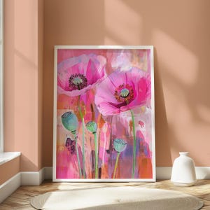 May include: A framed vertical wall art print featuring two large, vibrant pink poppy flowers in full bloom alongside three green, unopened poppy seed pods. The background is an abstract wash of pink, orange, and purple tones with visible brushstrokes.