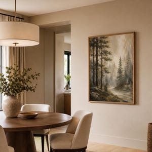 May include: A rectangular framed wall art print featuring a forest landscape with tall pine trees, a winding path, and soft, misty lighting in muted earth tones of brown, green, and beige, displayed on a plain, light-colored interior wall.