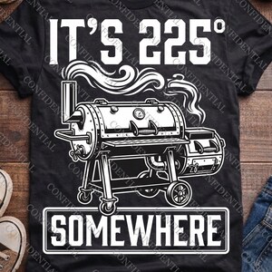 Puede incluir: Una camiseta negra con un gráfico blanco de un ahumador de barbacoa con humo saliendo de la chimenea. El texto superior dice IT'S 225° y el texto inferior dentro de un borde rectangular dice SOMEWHERE en letras mayúsculas blancas.