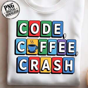 Peut inclure: Sweat-shirt blanc avec l'inscription "CODE COFFEE CRASH" en lettres colorées. Le mot "COFFEE" est orné d'un dessin de tasse à café bleue. Un logo "PNG - DIGITAL - DOWNLOAD" est visible en haut à gauche.
