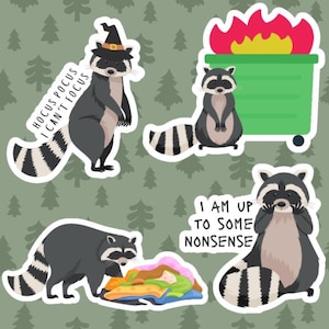 Puede incluir: Una colección de pegatinas de mapaches en varias poses. Un mapache lleva un sombrero de bruja, otro está cerca de un contenedor de basura en llamas, y otros tienen el texto "Hocus Pocus I Can't Focus" y "I Am Up To Some Nonsense".
