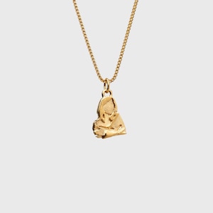 Peut inclure: Un collier avec un pendentif dor&eacute;. Le pendentif a une forme abstraite et organique. La cha&icirc;ne est une fine cha&icirc;ne dor&eacute;e. Le collier est pr&eacute;sent&eacute; sur un fond clair et uni.