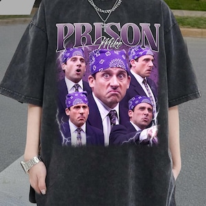 May include: Dark gray t-shirt featuring a graphic of Michael Scott from The Office wearing a purple bandana and the text "PRISON Mike". The design includes multiple images of Michael Scott. The shirt is a vintage style.