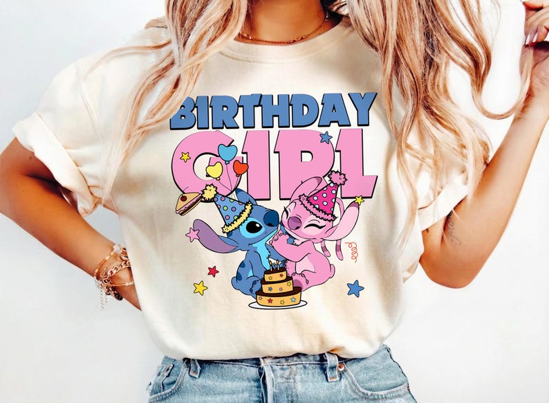 May include: Cream-colored t-shirt featuring the text "BIRTHDAY GIRL" in blue and pink. The design includes cartoon characters Stitch and Angel, wearing party hats, with a cake and stars.