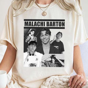 May include: A cream-coloured t-shirt displaying a black and white collage with the name "MALACHI BARTON" in bold letters. The collage features several black and white photos of a young man in different poses. A gold necklace is visible.
