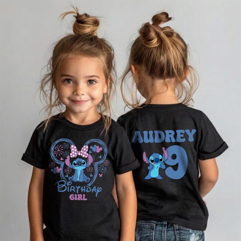 May include: Two young girls wearing black t-shirts with a Stitch-themed design. The front of the shirt features Stitch, a bow, and the words "Birthday Girl." The back of the shirt has the name "Audrey" and the number "9."
