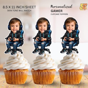 May include: Three cupcake toppers featuring a cartoon boy wearing headphones and holding a game controller, seated in a blue gaming chair. The toppers are placed above cupcakes with white frosting. Text reads "Personalized Gamer Cupcake Toppers" and "8.5 x 11 inch sheet".