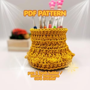 May include: Mustard yellow crochet pen and hook holder with the text "PDF PATTERN" and "pen & hook holder / basket macrame cord crochet". The handmade basket is filled with pens and crochet hooks. The holder has a flared base.