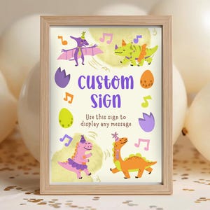 Puede incluir: Un letrero personalizado enmarcado con dinosaurios de dibujos animados, notas musicales y el texto "custom sign". El letrero presenta un Pterodáctilo morado, dinosaurios verdes y naranjas, y el texto "Use this sign to display any message".
