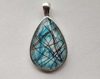 May include: A silver teardrop-shaped pendant with a blue and black marbled design. The pendant is made of resin and has a silver bail.