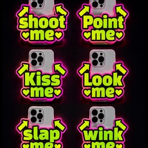 Pode incluir: Seis capas brancas para smartphone com texto e setas em amarelo néon com bordas cor-de-rosa brilhantes. O texto diz: shoot me, Point me, Kiss me, Look me, slap me e wink me, cada um acompanhado por dois pequenos corações cor-de-rosa.