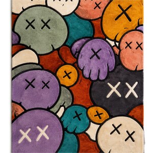 Puede incluir: Una alfombra rectangular con un patr&oacute;n denso y superpuesto de formas redondeadas tipo dibujos animados en varios colores, incluyendo morado, verde, naranja, negro y beige. Cada forma presenta un distintivo motivo de ojo en forma de X.