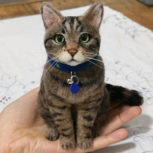 Puede incluir: Un juego de tres tazas de cerámica con un acabado mate moteado. Las tazas son de color azul, verde y blanco. Cada taza tiene un asa redondeada y un diseño simple y moderno. Las tazas están apiladas una encima de otra.