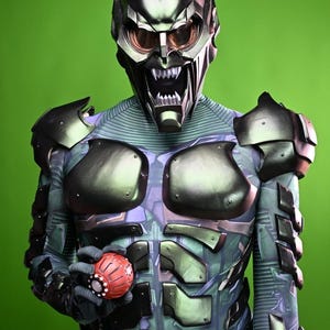 May include: A detailed costume of the Green Goblin, featuring a metallic green and black helmet with menacing teeth and eye lenses. The suit has a green and blue color scheme with armored plating and a red, spherical grenade.
