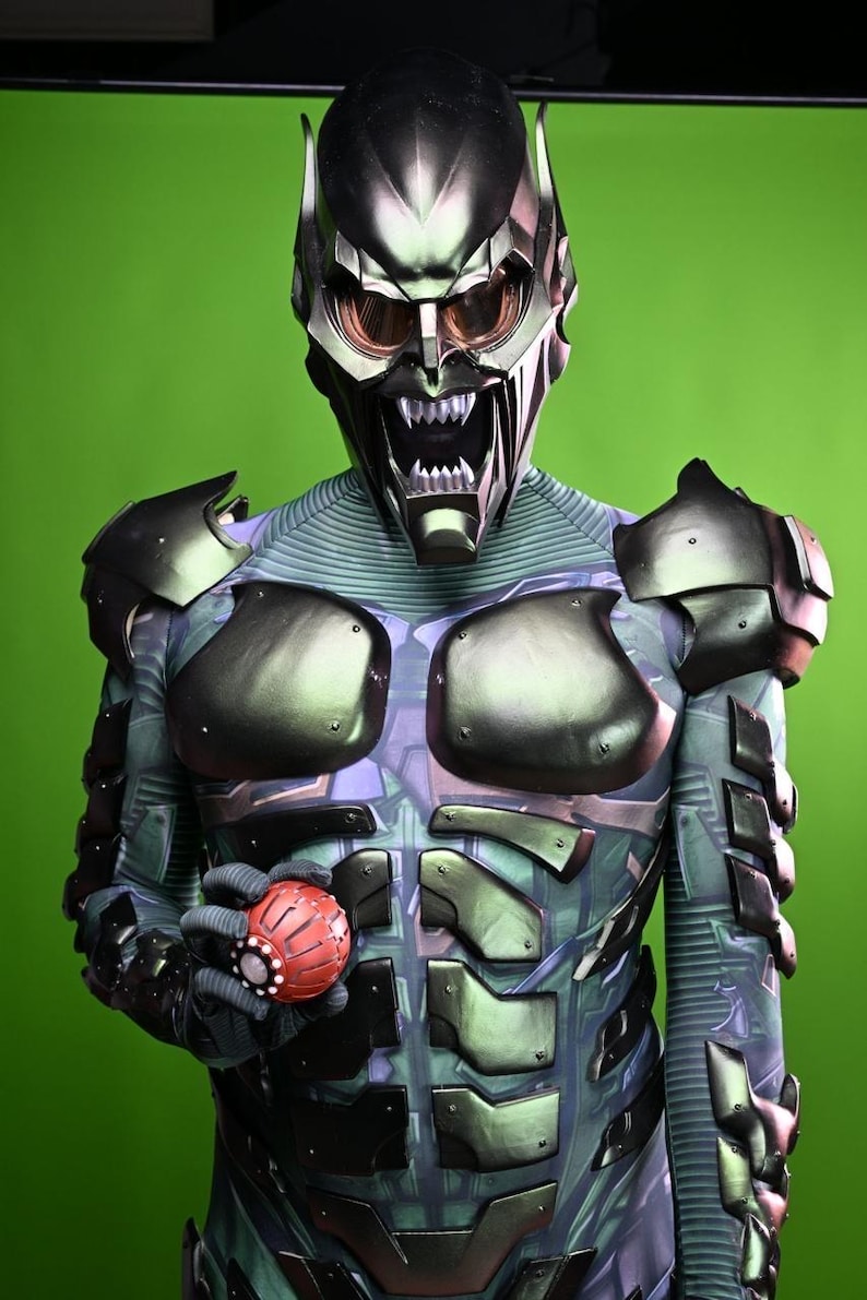 May include: A detailed costume of the Green Goblin, featuring a metallic green and black helmet with menacing teeth and eye lenses. The suit has a green and blue color scheme with armored plating and a red, spherical grenade.