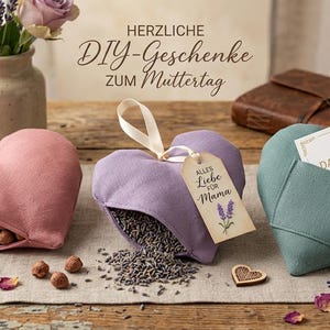 May include: Three heart-shaped gifts, one pink filled with nuts, one purple with lavender, and one teal with a card. The gifts are on a wooden table with lavender and rose accents. Text reads "DIY Gifts for Mother's Day."