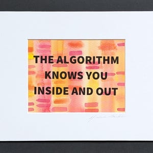 May include: A framed art print with the text "THE ALGORITHM KNOWS YOU INSIDE AND OUT" in black. The background features a watercolor design with orange, yellow, and pink hues. The print is matted in white and set against a black background.
