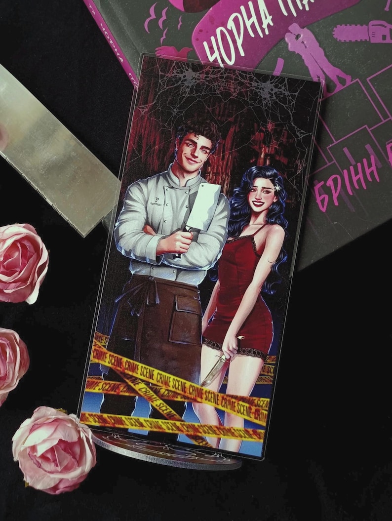May include: A bookmark featuring a couple with a chef and a woman in a red dress, holding a cleaver and a knife. The background has a spiderweb design and crime scene tape. The text "Чорна" and "БРІНН" are visible.
