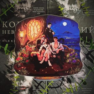 May include: A fantasy book cover with a group of people in a forest setting, under a night sky with a moon. The cover has a dark, gothic theme with text in a foreign language and a skull in the background.