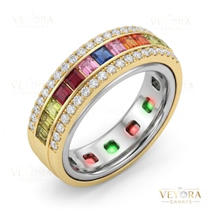 May include: A gold band ring featuring a central row of baguette-cut multi-coloured gemstones including red, pink, blue, orange, and green, flanked by two rows of small round white diamonds, with a silver inner band showing coloured stone cutouts.