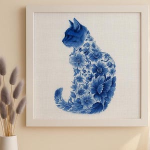 May include: Framed artwork of a blue cat silhouette filled with blue floral patterns. The cat is in profile against a white background. The artwork is in a white frame, suitable for home decor, with a cross-stitch effect.