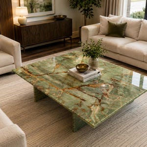May include: A square coffee table featuring a polished green stone surface with prominent brown veining and a thick slab base. The table is positioned in a living room setting, displaying a reflective finish that highlights the natural stone pattern.
