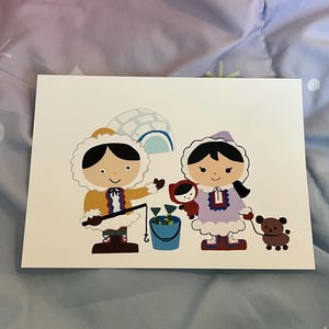 May include: A greeting card featuring a colorful illustration of two Inuit children. One child is fishing, and the other is holding a doll and a small brown bear. An igloo is in the background. The card is on a white background.