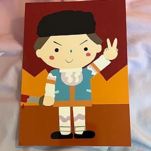 May include: A rectangular card featuring a cartoon illustration of a figure in a blue jacket, white pants, and a black hat. The figure holds a knife and makes a peace sign. The background is red and orange.