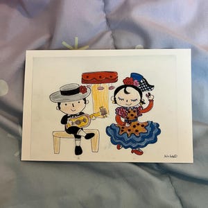 May include: A hand-drawn illustration of a flamenco dancer and a musician. The dancer wears a red and brown dress with a blue ruffled skirt. The musician sits on a bench and plays a yellow guitar. The artwork is on a white rectangular card.