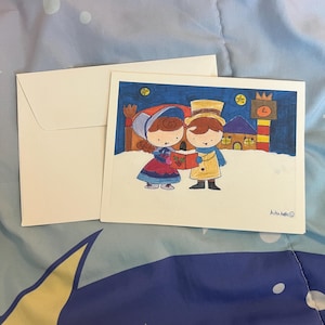 May include: A greeting card with a winter scene illustration. The card features a couple in winter attire, holding hands in front of a snowy backdrop with buildings. An envelope is next to the card. The illustration is signed by the artist.