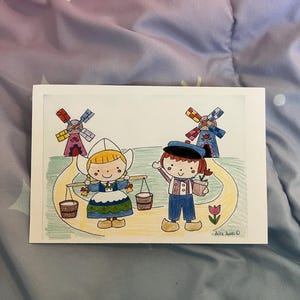 May include: A colorful drawing of two Dutch children with windmills in the background. One child carries buckets, and the other holds a potted plant. The artwork is signed "Aika Ando".