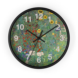 Puede incluir: Un reloj de pared redondo con marco negro. La esfera del reloj presenta un colorido diseño floral con girasoles y otras flores. Números blancos marcan las horas y manecillas negras indican la hora.