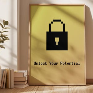 May include: A framed print featuring a black pixelated padlock on a yellow gradient background. The text "Unlock Your Potential" is printed below the padlock in a simple font. The frame is a light wood color.