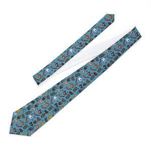 May include: A teal necktie with a repeating pattern of cat faces, combs, and dots. The tie is made of a smooth fabric and has a white lining. The cat faces are in various colors, including brown, orange, and gray.